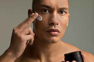 Studio portrait of man applying face cream