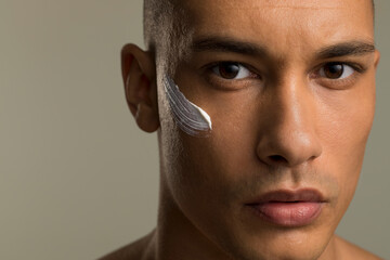 Close-up of man with face cream on cheek