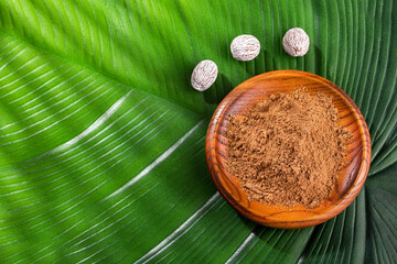 Organic nutmeg powder in the wooden bowl - Myristica