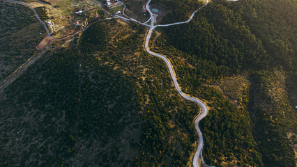 Top view of a bending single lane road among bushes.