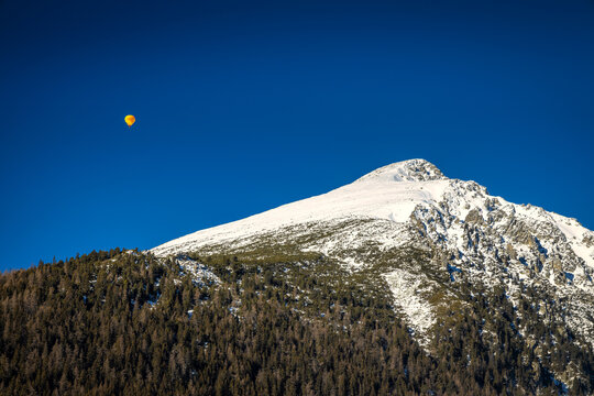 Flying balloon over the snowy mountain Solisko in the High Tatras National Park, Slovakia, Europe.