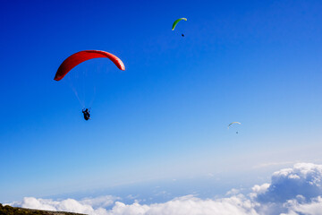 Fototapeta na wymiar Athletes use an ultralight flexible glider, paraglider, to fly above the clouds.