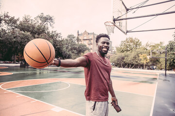 Fototapeta premium USA, Pennsylvania, Philadelphia, Smiling man with ball at basketball court