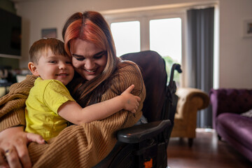 Woman on wheelchair hugging son