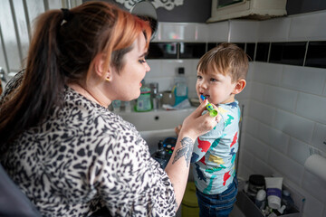 Mother brushing sons teeth - obrazy, fototapety, plakaty