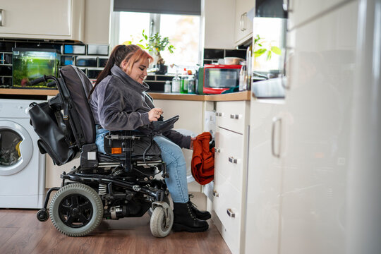 Woman in wheelchair doing laundry
