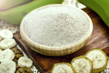 homemade green banana flour, with fruit in the background and fried banana chips and slices around