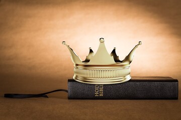 The Holy Bible and a Kings Crown on a desk