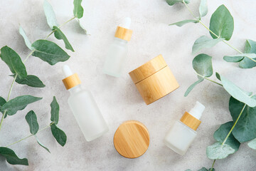 Eco cosmetics set with green eucalyptus leaves on stone table. Natural organic SPA beauty products packaging design, branding