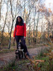 Woman hiking in forest with dogs