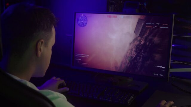 Young Gamer Playing Internet FPS Video Game On Modern PC. Gamer Lost Internet Multiplayer Match In FPS Computer Game. Gamer Playing With Sniper Rifle In Military FPS Game. Internet Battle. Shooter