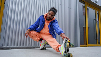 Young man wearing roller skates stretching by iron wall