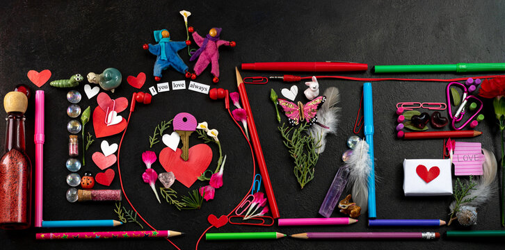 Valentines Day flat design on black background, the word LOVE spelled with art and office supplies with cut out folded hearts, gender neutral characters, butterfly and carnation petals