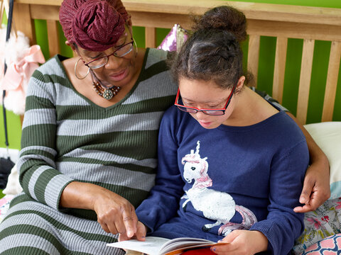 Mother And Daughter With Down Syndrome Reading Book