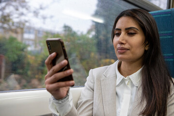 Businesswoman using smart phone in commuter train