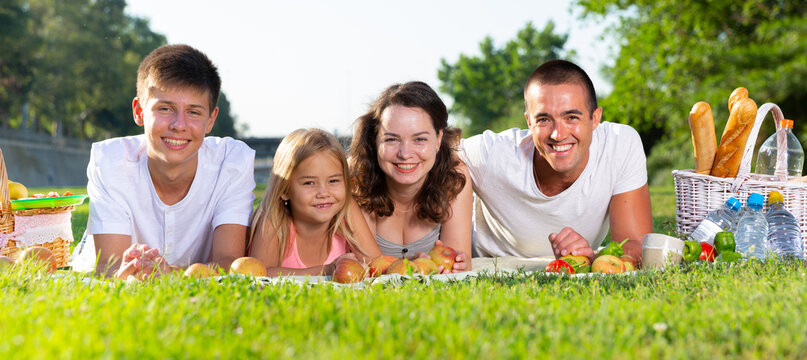 Portrait of friendly family on a green meadow. High quality photo