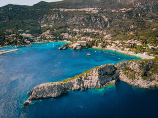 Aerial view of Paleokastritsa bay on a sunny day. Bay with beautiful turquoise water and boats.