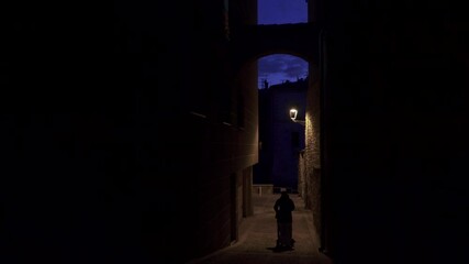 Late night delivery, a shadowed man pushes a dolly down a dimly lit street in the middle of the night. - Powered by Adobe