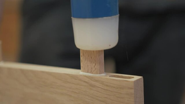 Hammering oak domino into biscuit jointer recess Close Up