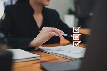 Close up Business woman hand holding pen and selecting the best insurance and saving money plan.