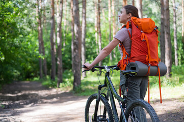 Fototapeta premium Caucasian woman rides a bicycle in the forest