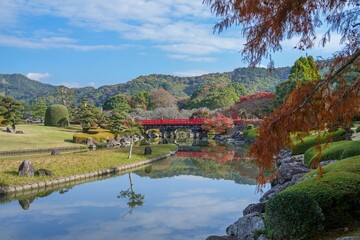 Obraz premium 鮮やかな朱色の橋がある日本庭園の秋の情景＠愛媛