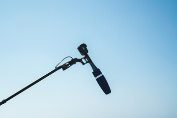An airplane flying in the sky and a microphone on a tripod. Airplane and flight news concept.
