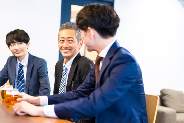 Fototapeta premium バーで乾杯をする3人の会社員