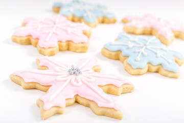 Christmas sugar cookies in the shape of snowflakes with pastel colored frosting.