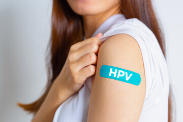 HPV (Human Papillomavirus) Teenager woman showing off an blue bandage after receiving the HPV...