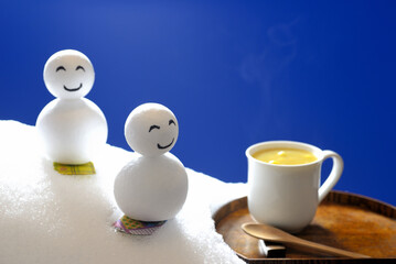 スノーボードをする雪ダルマとコーンスープ