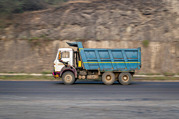 Intentional camera movement, Slow shutter speed motion blur image of a tipper truck speeding on a highway.