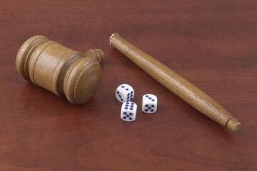 Dices and broken judge gavel on wooden table. Gambling against laws concept.