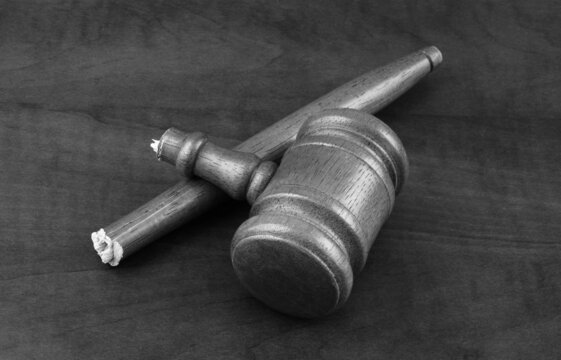 Broken wooden judge gavel on table. Concept of lawlessness, injustice and not working court.