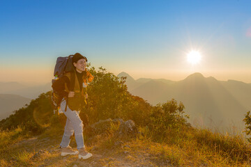 Obraz premium young female tourist carrying luggage at sunset