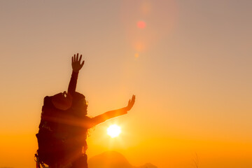 Fototapeta premium young female tourist carrying luggage at sunset