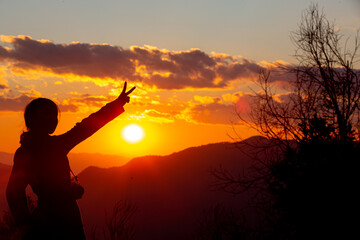 young female tourist carrying luggage at sunset