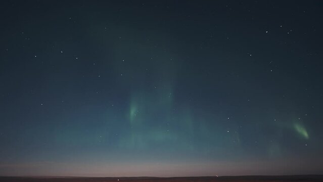 A timelapse of the beautiful display of the pale lights of the aurora on the starry night sky.