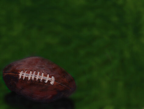 American football on green turf with space for text
