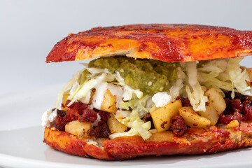 Pambazo, mexican street food meal. Pambazo is sandwich made of bread, potatoes, chorizo, lettuce, sour cream and sauce.