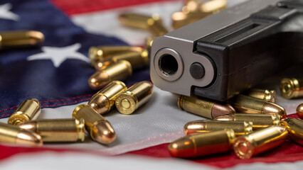 Detail of gun barrel with many bullets on American flag. Concept of gun control and carry of...