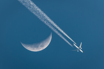 Photo of an airplane flying over the moon