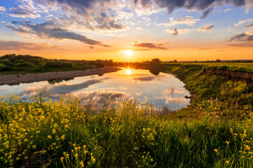 Fototapeta na wymiar Amazing view at scenic landscape on a beautiful river and colorful sunset with reflection on water surface and glow on a background, spring season landscape
