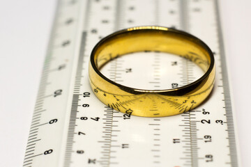 A gold ring on a ruler, a measuring tool in a pawnshop, determining the size of jewelry