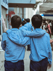 Two blind boys supporting each other as they walk cautiously on a busy street. Sightless children holding each other to protect from obstacles on their path.