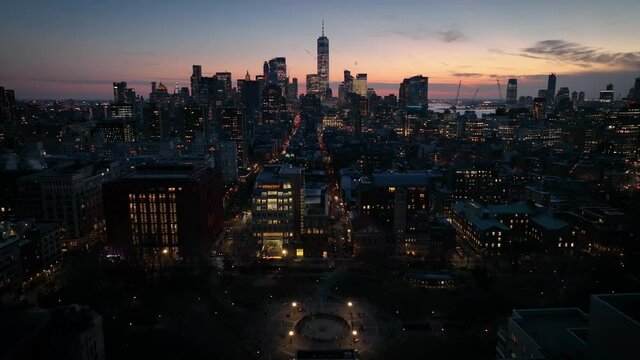 sunset view of downtown NYC flying backwards over Washington Square Park