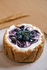 Top view of plate with Blueberry Cheesecake, pie, art. Closeup shot of berries and Rosemary placed on top. Tasty fresh baked dessert.