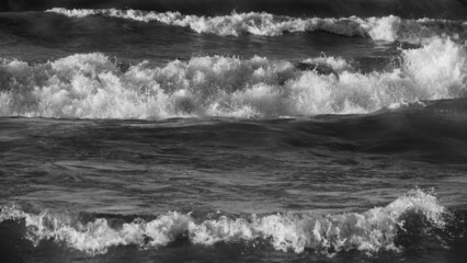 black and white image of waves of lake Ontario crashing into water on stormy day grey and white natural natire scenic horizontal format room for type backdrop background wallpaper