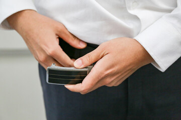 The groom tightens his belt. A man holding his hands on his belt. Morning wedding preparation.