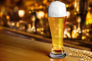 Glass of beer with foam Served in stylish old brick wall interior.